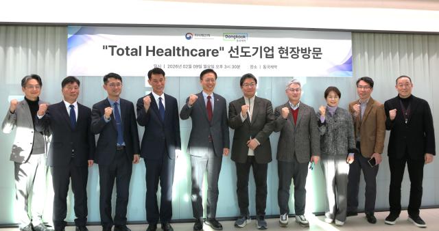 Kim Yongseon, commissioner of the Korean Intellectual Property Office, and Dongkook Pharmaceutical CEO Song Junho pose with attendees at a meeting. Photo provided by Dongkook Pharmaceutical.