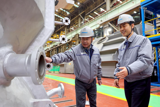 박정원 두산그룹 회장왼쪽이 11일 경남 창원 두산에너빌리티 사업장을 방문해 제작 중인 발전용 가스터빈 제품을 살펴보고 있다 사진두산