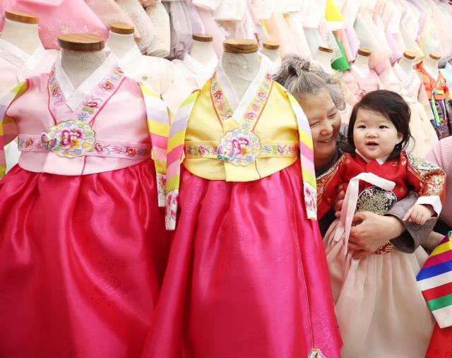 A child tries on a hanbok at a shop in Yeongdong Market in Paldal-gu Suwon Gyeonggi Province on Feb 12 five days ahead of the Seollal holiday Yonhap