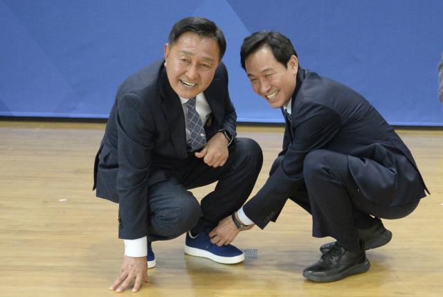 우상호 전 청와대 수석이 김세훈 작가에게 화천군민들의 목소리를 향해 멈추지 않고 걷겠다는 약속의 의미와 화천을 위해 더 힘차게 뛸 수 있도록 격려의 마음을 담아 신발 끈 조여주는 퍼포먼스를 하고 있다사진박종석 기자