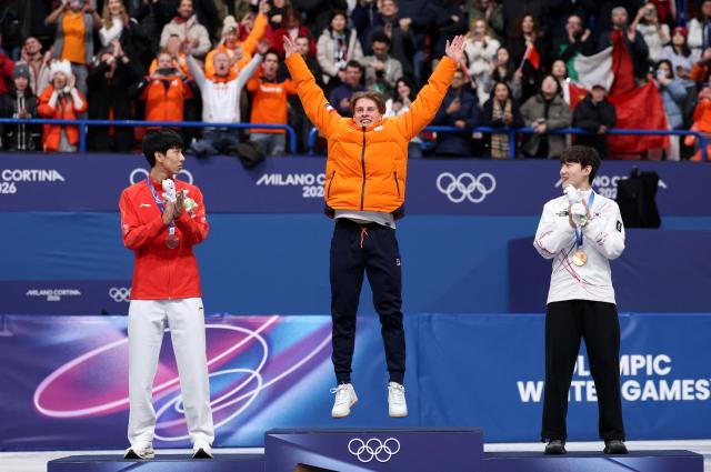 Milano Cortina 2026 Olympics - Short Track Speed Skating - Mens 1000m - Victory Ceremony - Milano Ice Skating Arena Milan Italy - February 12 2026 Gold medallist Jens van t Wout of Netherlands celebrates on the podium after winning the Mens 1000m with Silver medallist Long Sun of China and Bronze medallist Jongun Rim of South Korea REUTERSClaudia GrecoCourtesy of Yonhap News Agency