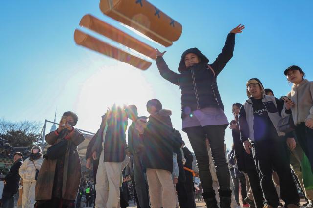 A visitor throws yut sticks while playing the traditional game yunnori during the “2026 Namsangol Seollal Festival” at Namsangol Hanok Village in Jung District Seoul on Feb 17 2026 AJP Yoo Nahyun