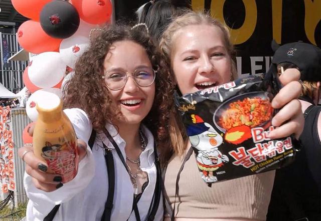 외국인들이 삼양식품 붉달볶음면과 불닭소스를 들어 보이고 있다 사진삼양식품