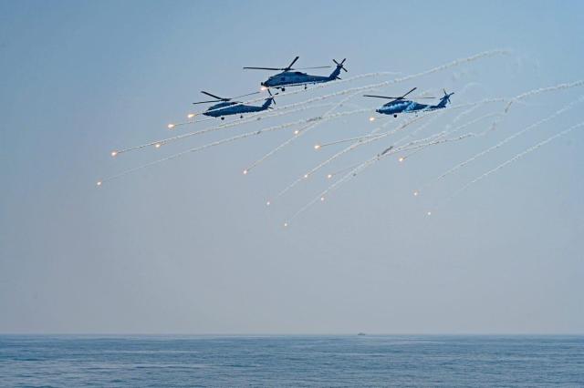 Indian naval helicopters deploy flares during an aerial demonstration at the IFR 2026 in Visakhapatnam on Feb 18 Courtesy of the Ministry of Defence Government of India