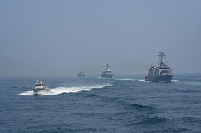 Indian Navy ships sail in formation during the IFR 2026 off the coast of Visakhapatnam while a fast patrol craft escorts the formation on Feb 18 Courtesy of the Ministry of Defence Government of India