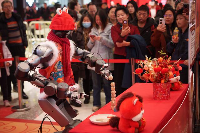 19일 중국 베이징의 한 절에서 휴머노이드 로봇이 붉은색 모자와 목도리를 두른 채 공연하고 있는 모습 사진AP연합뉴스 