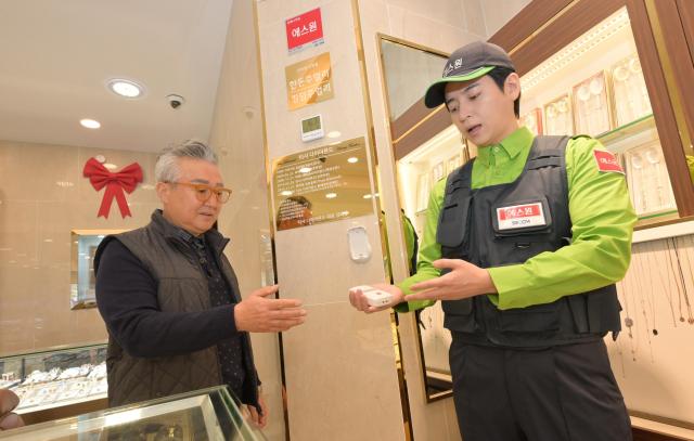 에스원 직원이 귀금속점 점주에게 맞춤형 AI 보안 솔루션을 설명하고 있다 사진에스원