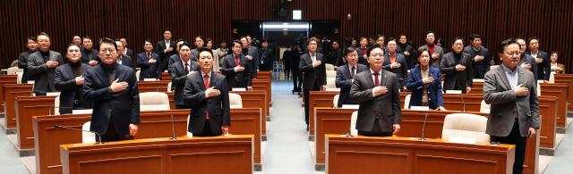 장동혁 국민의힘 대표와 송언석 원내대표를 비롯한 참석 의원들이 지난 12일 국회에서 열린 의원총회에서 국기에 경례하고 있다사진연합뉴스