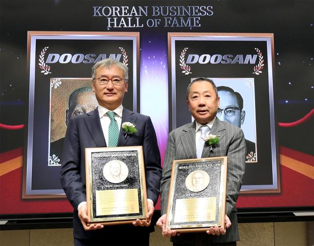 24일 서울 이화여대 경영대학 60주년 기념홀에서 열린 ‘대한민국 기업가 명예의 전당’ 헌액식에서 박정원 두산그룹 회장오른쪽이 헌액 기념패를 들고 양희동 한국경영학회 회장왼쪽과 함께 기념촬영을 하고 있다 사진두산