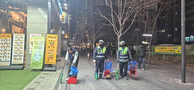 이현재 하남시장이 지난 21일 저녁 미사문화거리에서 시 소속 환경공무관들과 함께 빗자루를 들고 야간 청소 정화 활동을 펼치고 있다 사진하남시