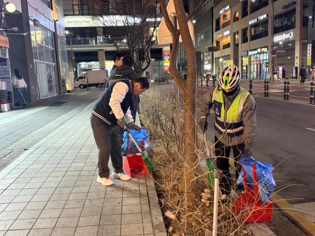 이현재 하남시장이 지난 21일 저녁 미사문화거리에서 시 소속 환경공무관들과 함께 빗자루를 들고 야간 청소 정화 활동을 펼치고 있다 사진하남시