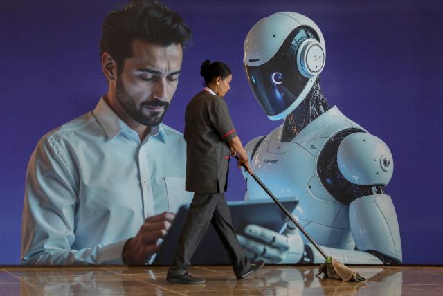 A worker sweeps next to an AI hoarding at the AI Impact Summit 2026 at Bharat Mandapam in New Delhi India 18 February 2026 India hosted the AI Impact Summit 2026 from 16 to 20 Feb 2026 EPA-Yonhap 