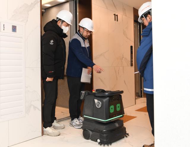 포스코이앤씨 관계자들이 신반포 21차 주택재건축정비사업 현장에서 준공청소에 자율주행 청소 로봇을 투입하기 위한 기술적 운용 방안을 논의하고 있다사진포스코이앤씨