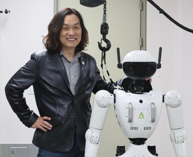 Han Jae-kwon professor of robotics at Hanyang University and CTO of Aei Robot poses for a photo beside his teams Alice 4 model Feb 23 2026 AJP Han Jun-gu