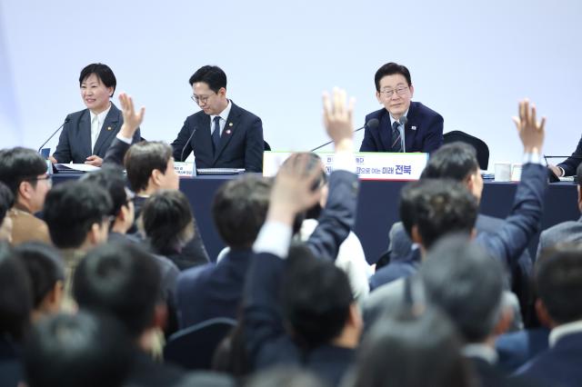 27일 전북 전주시 전북대학교에서 이재명 대통령이 참석한 가운데 열린 전북의 마음을 듣다 타운홀미팅 간담회에서 참석자들이 손을 들며 발언권을 요청하고 있다 사진연합뉴스
