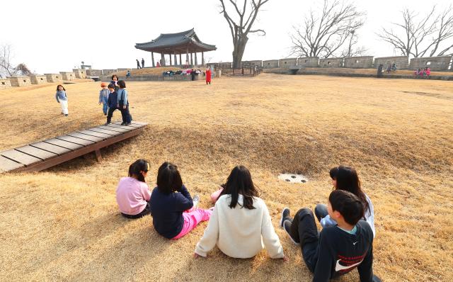 포근한 날씨를 보인 5일 인천 강화군 연미정으로 겨울방학 현장체험학습을 나온 어린이들이 두꺼운 외투를 벗어놓고 잔디에 안자 휴식하고 있다 202625 사진연합뉴스