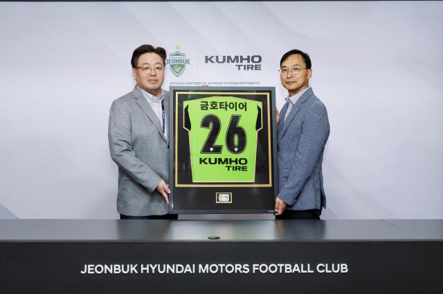  윤민석 금호타이어 G마케팅담당 상무와 이도현 전북현대모터스  단장이 공식 파트너십 연장 조인식을 체결한 뒤 금호타이어 로고가 적용된 유니폼 액자를 들고 기념사진을 찍고 있다사진금호타이어
