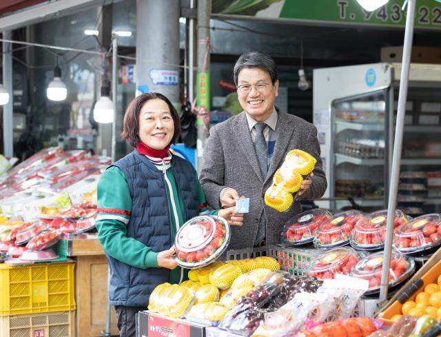 지난달 27일 김돈곤 청양군수가 농어촌 기본소득 지급 첫날 청양 전통시장을 방문해 물품을 구매하며 상인들의 애로사항을 청취하고 있다사진청양군