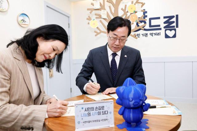 정명근 화성특례시장과 송혜자 블루웍스 대표기부자가 그냥드림 내부 희망나무에 전시할 메세지를 쓰고 있다 사진화성시