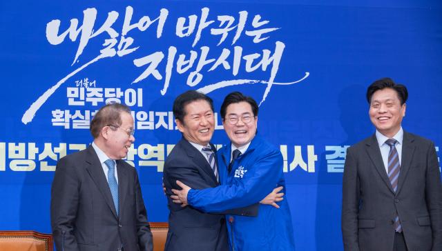 정청래 더불어민주당 대표왼쪽 둘째가 4일 더불어민주당 인천시장 후보로 결정된 박찬대 의원왼쪽 셋째에게 당의 후보를 상징하는 파란 점퍼를 입혀준 뒤 포옹하고 있다 사진연합뉴스