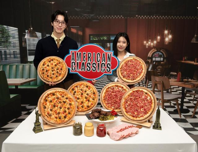 도미노피자의 아메리칸 클래식 신제품 피자 출시를 기념해 모델들이 신제품을 들고 포즈를 취하고 있다 사진도미노피자