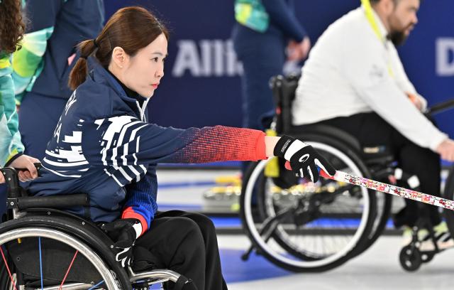 Baek Hye-jin of South Korea delivers a stone during the wheelchair curling mixed doubles preliminary match against Japan at the Cortina Curling Olympic Stadium Stadio Olimpico del Ghiaccio in Cortina d’Ampezzo Italy during the 2026 Milan–Cortina Winter Paralympics on Mar 5 2026 local time Photo pool 2026 0306