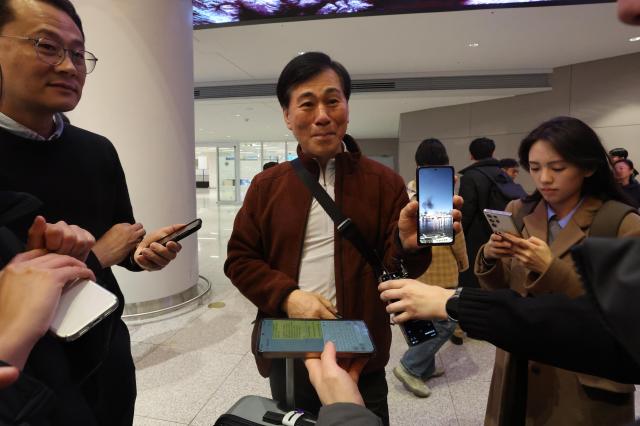 A traveler who returned from the Middle East shows photos taken locally and speaks with reporters at Incheon International Airport March 5 Yonhap