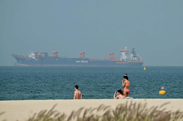 People relax on the beach with commercial vessels anchored off shore in Dubai on March 2 2026 The United States hit hundreds of targets across Iran and Israel expanded its bombing to Lebanon on March 2 as US President Donald Trump vowed to avenge the first US deaths in the war he launched to topple Tehrans ruling clerics Iranian forces fired missiles and drones across the Middle East killing people in Israel and the United Arab Emirates in retaliation for the conflict that began Saturday with the death of Irans supreme leader Ayatollah Ali Khamenei AFPYONHAP