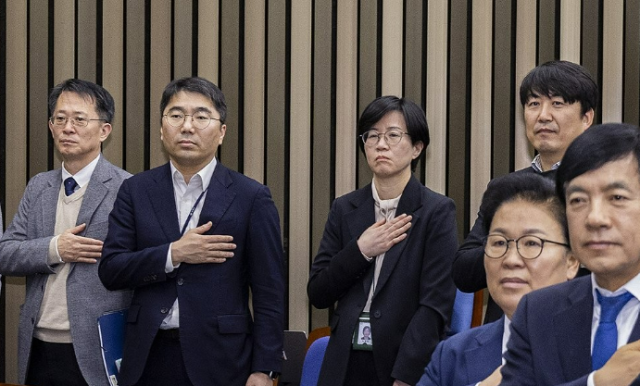 지난달 5일 국회에서 열린 더불어민주당 정책 의원총회에 공소청법·중수청법에 대한 정부안을 설명하기 위해 국무총리실 산하 검찰개혁추진단 관계자들이 국기에 경례하고 있다 사진연합뉴스 