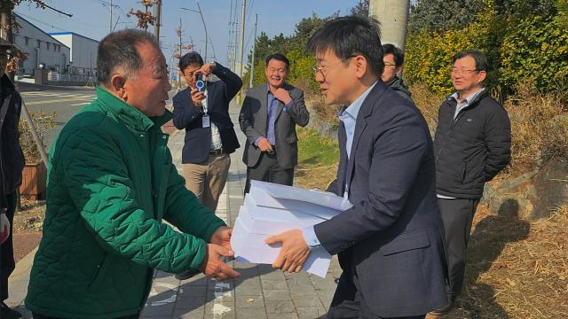 새만금 RE100 국가산업단지 부안유치 범군민추진위원회 회원들이 새만금개발청 관계자에게 새만금 RE100 국가산업단지 유치를 위한 주민서명부를 전달하고 있다사진부안군