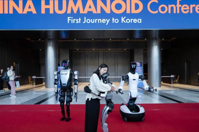 왼쪽부터 레쥬 유니트리 애지봇의 휴머노이드 로봇이 차이나 휴머노이드 로봇 컨퍼런스 입구에 전시돼 있다 사진AW 2026