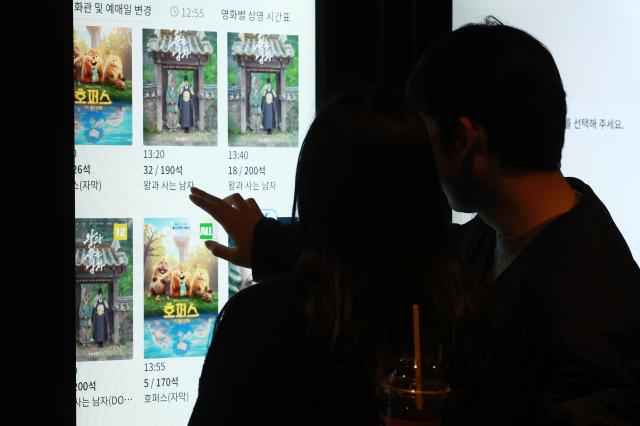Moviegoers purchase tickets at a cinema in Seoul March 8 Yonhap