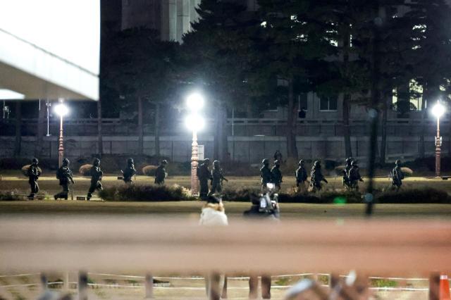 Martial law forces that had entered the National Assembly building in Yeouido are seen withdrawing on foot moments after the resolution to lift martial law was passed at about 100 am on Dec 4 AJP Kim Dong-woo