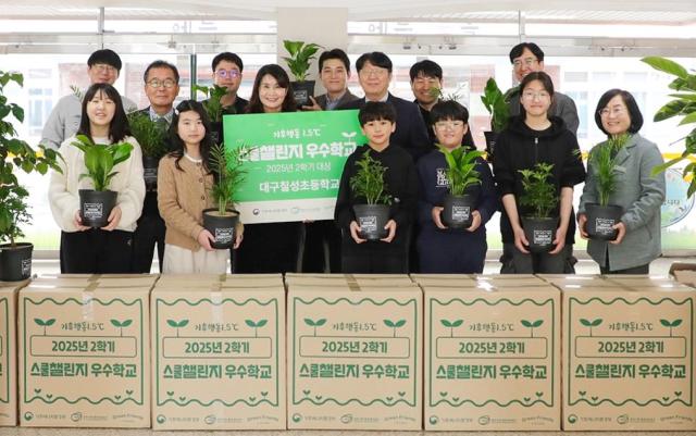지난 9일 더현대 대구 임직원들이 기후에너지환경부 탄소중립 프로그램 기후행동 15℃ 스쿨챌린지에서 초등학교 부문 대상을 받은 대구 칠성초등학교를 방문해 공기정화식물을 전달하고 학생 및 교사들과 기념사진을 찍고 있다 사진현대백화점