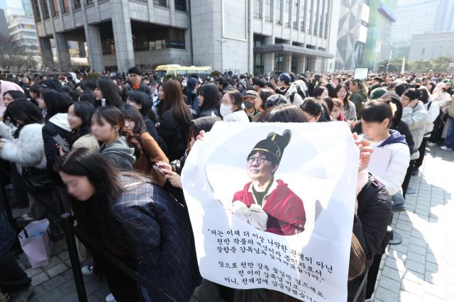 A citizen holds up a self-made banner during a coffee truck event hosted by director Jang Hang-jun to thank audiences for the box-office success of the film The King's Warden at the Korea Press Center Plaza in central Seoul on March 12, 2026. Yonhap. 2026.03.12