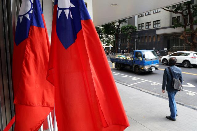 A man walks past Taiwan flags on a street amid Chinas Justice Mission 2025 military drills around Taiwan in Taipei Taiwan December 29 2025 Reuters-Yonhap 