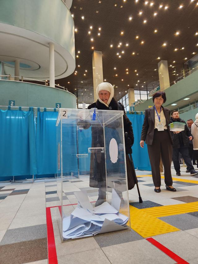 An elderly voter inserts her ballot into a ballot box at the Al-Farabi Palace of Schoolchildren on March 15 to cast her vote in the national constitutional referendum AJP Park Sae-jin