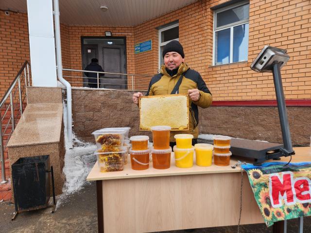 A stall operator holds up a honeycomb for sale outside School-Lyceum No 3 on March 15 during the national constitutional referendum AJP Park Sae-jin
