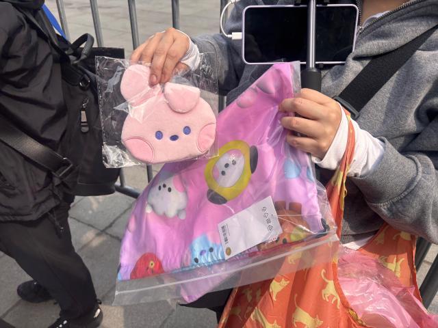 A fan shows BT21 merchandise purchased at a LINE Friends store ahead of the group’s comeback concert at Gwanghwamun Square in Seoul March 16 2026 AJP Ryu Yuna