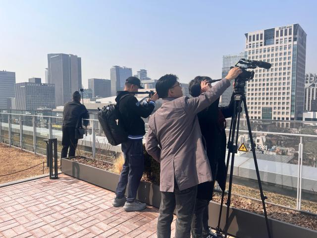 Visitors are gathered around the fence to take photos and videos of the construction sight of BTS stages. AJP Joonha Yoo