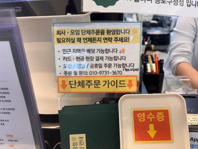 A sign in front of a fast food shop in Jonggak near Gwanghwamun inviting advance delivery bookings AJP Ryu Yuna