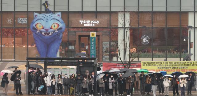 People wait for a bus with umbrellas in Jung-gu Seoul March 18 2026 AJP Han Jun-gu