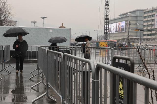 Photo shows pedestrians walking alongside safety fences put in place for preparation for upcoming BTS' Comeback Concert on March 21. AJP Han Jun-gu March 18, 2026