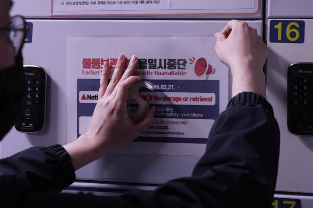 An official attaches a notice announcing temporary suspension of lockers at City Hall Station in Seoul March 18 2026 AJP Han Jun-gu 20260318