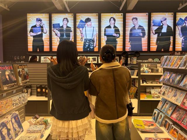 Two fans from Japan pose at a K-pop merchandise shop in Myeongdong Seoul on March 18 2026 AJP Ryu Yuna