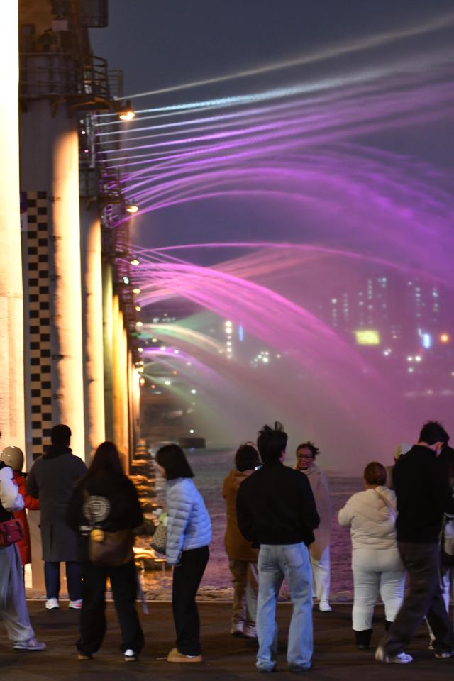 Fans are line up by the riverside taking photos as the fountain turned purple March 18 2026 AJP Joonha Yoo
