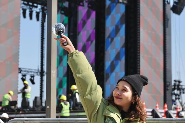A fan holds a light stick near the stage at Gwanghwamun Square in central Seoul ahead of the BTS comeback concert on March 19 2026 AJP Han Jun-gu
