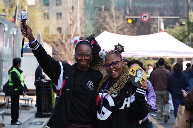 ARMY fans pose for a photo while waiting for the BTS concert at Gwanghwamun Plaza in Seoul March 21 2026 AJP Han Jun-gu