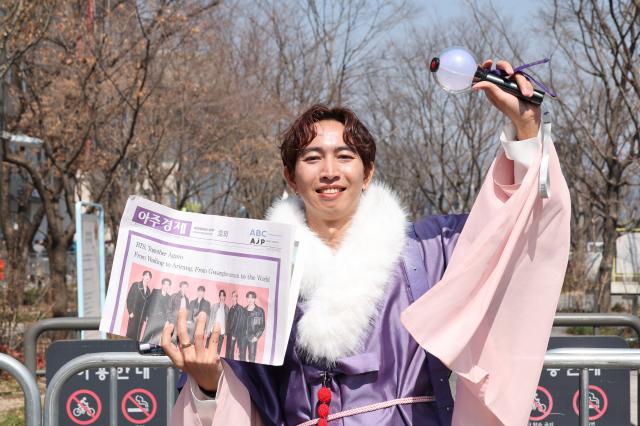 An ARMY fan poses holding an ARMY Bomb while waiting for the BTS concert at Gwanghwamun Plaza in Seoul March 21 2026 AJP Yoo Na-hyun