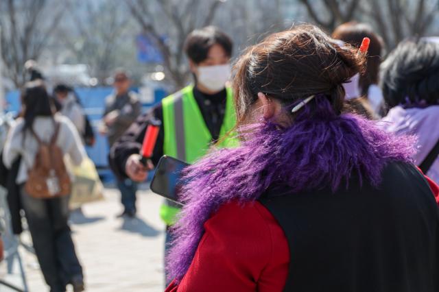 An ARMY wears a purple fur scarf while waiting for the BTS concert at Gwanghwamun Plaza in Seoul March 21 2026 AJP Yoo Na-hyun